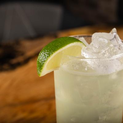 Margarita cocktail, closeup on a glass edge with attached lime.