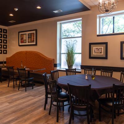 Interior, big round table, chairs, banquette seating.