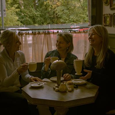 People sitting at the cafe table with drinks.