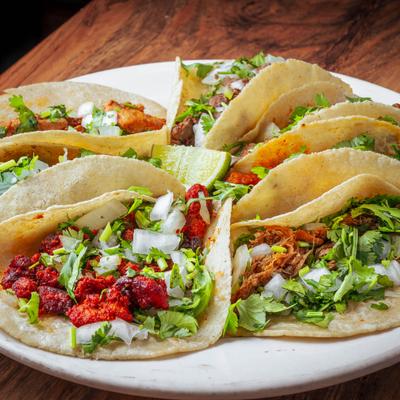 Taco Platter with various tacos topped with diced onions and cilantro.
