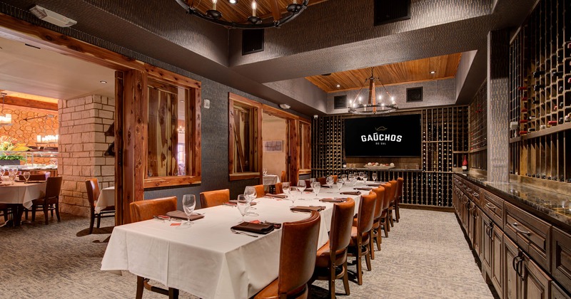 Interior, wine room with wine racks and a long set table for guests