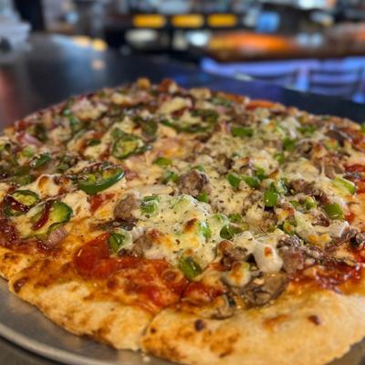 Pizza with meat, cheese, onions, and jalapenos.