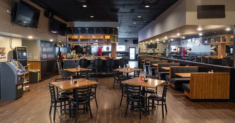 A cozy bar interior with wooden tables and chairs