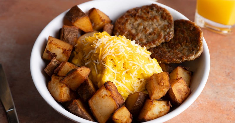 Scrambled eggs, with cheese, sausage patties, and country potatoes