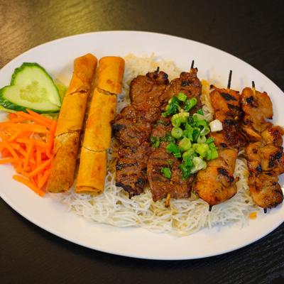 Grilled beef, chicken, and shrimp skewers, with spring rolls, rice, and veggies.
