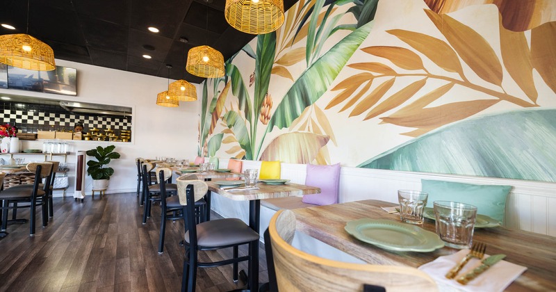 A restaurant interior with a tropical mural