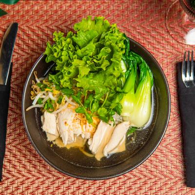 Chicken noodle soup with fresh lettuce, bean sprouts and bok choy.