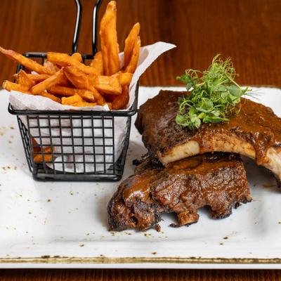 Glazed baby back ribs served with sweet potato fries.