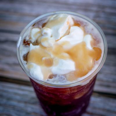 ice coffee with whip and caramel drizzled on top.