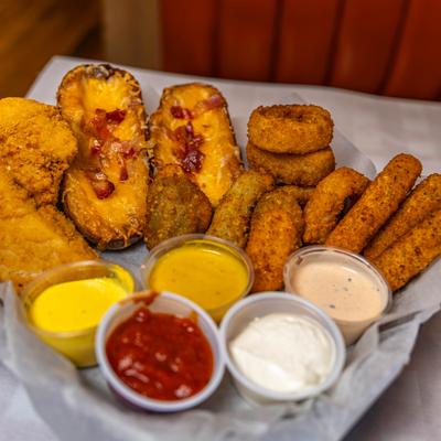 Fried appetizer platter with potato skins, mozzarella sticks, onion rings, and dipping sauces.