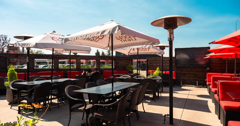 Patio, umbrellas, outdoor tables and chairs, red booth seating, patio heaters, flower planters