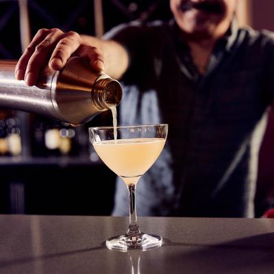 A hand pouring a martini.