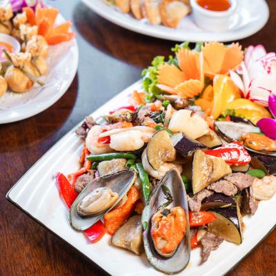 Seafood and vegetable stir-fry with mussels, shrimp, and carved vegetable garnish.