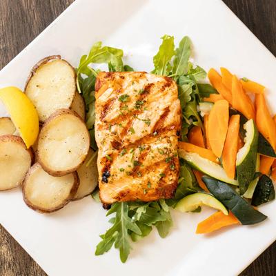 Grilled Salmon served with seasonal vegetables and roasted potatoes.
