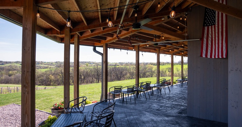 Exterior, patio, covered seating area,  wooden deck, tables with chairs, hanged  American flag