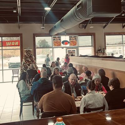 People dining in the restaurant with a Christmas tree in the background.