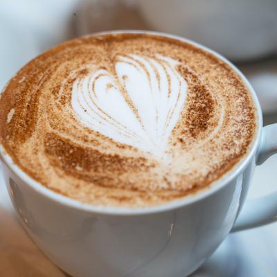 Latte with cinnamon dusting and heart-shaped latte art.