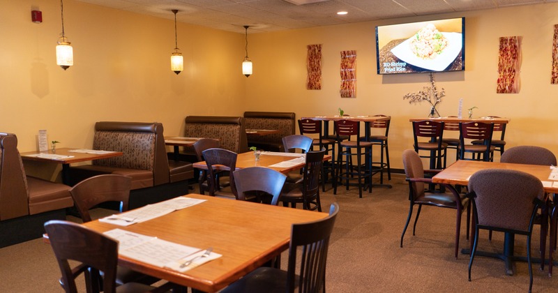 Interior, booths and tables for dining, a TV and wall decorations