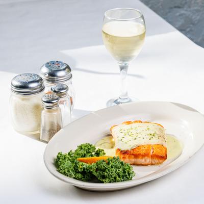 Salmon with creamy dill sauce with a glass of white vine.