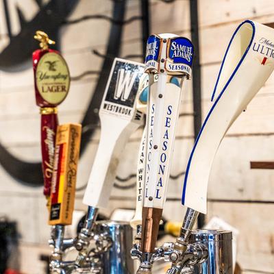 Assorted beer taps on bar counter.