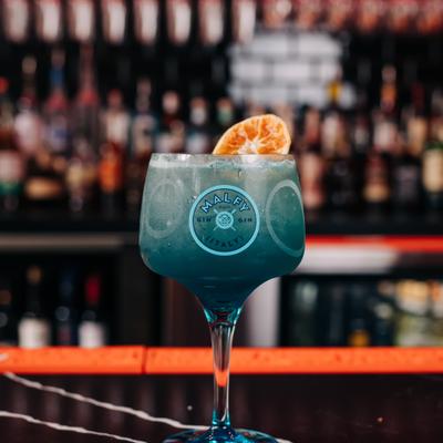 Angelo Azzurro Martini cocktail garnished with a dehydrated orange wheel.