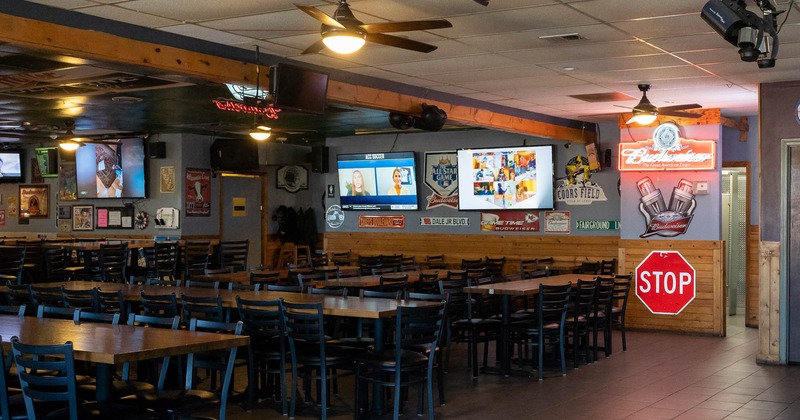 Interior, tables and seats in dining area, TVs and decorations on walls