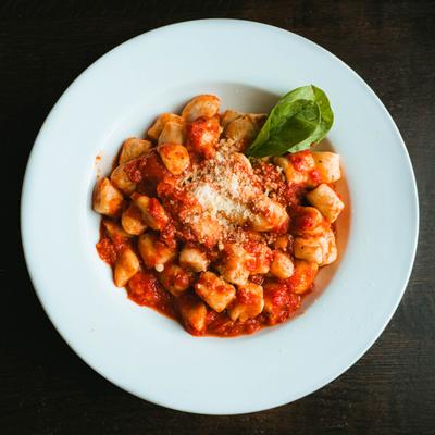Homemade potato gnocchi with tomato sauce, grated cheese and fresh basil.