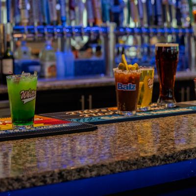 Variety of cocktails and draft beers served on the bar counter.