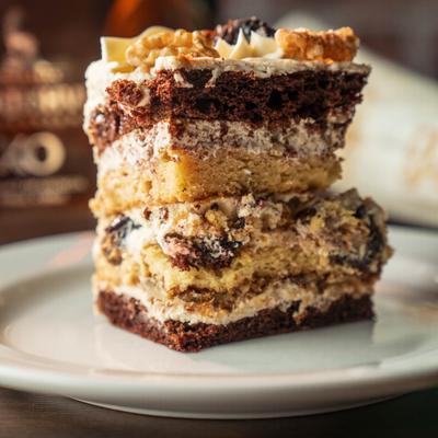 Russian Plum Cake featuring layers of chocolate sponge, walnuts, and cream.