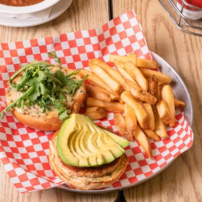 Grilled salmon sandwich with avocado, arugula, caper aioli, and fries.