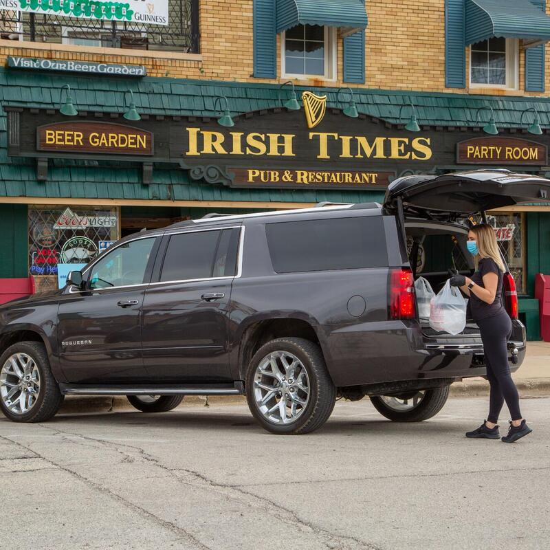 Exterior irish times entrance and parking lot, woman loading a car