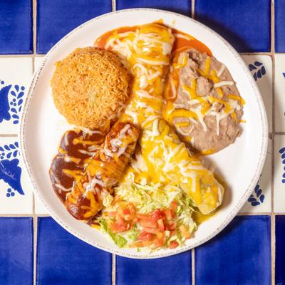 Three enchiladas served with lettuce, tomato, rice and, refried beans.