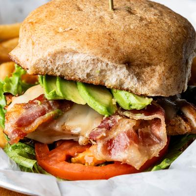 Chicken sandwich with bacon, Swiss, avocado, lettuce, tomato, and mayo.