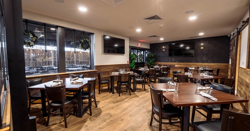 Interior,  tables and chairs ready for guests with TV on the wall