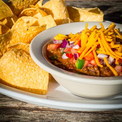 Chili topped with cheese served with tortilla chips.