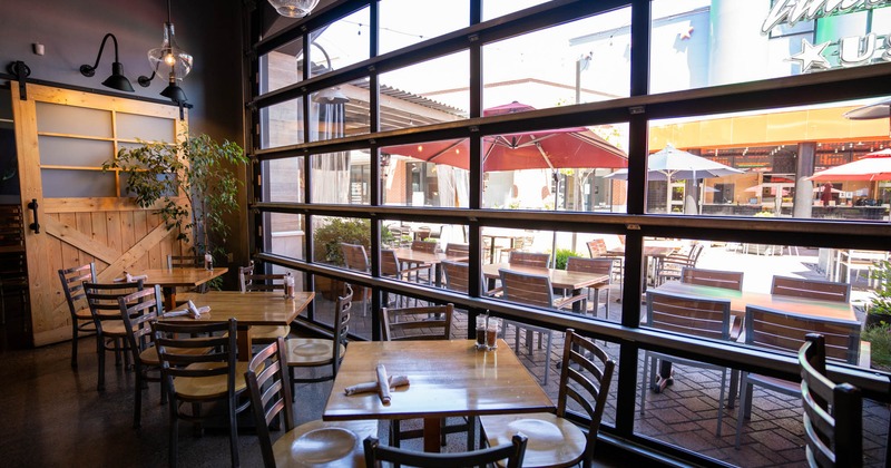 Tap & Vine interior, seating area by the windows, tables and chairs