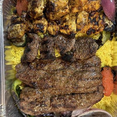 Grilled beef and chicken over a bed yellow rice