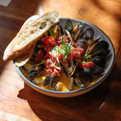 Sauteed mussels, with white wine, butter, tomatoes, and served with bread.