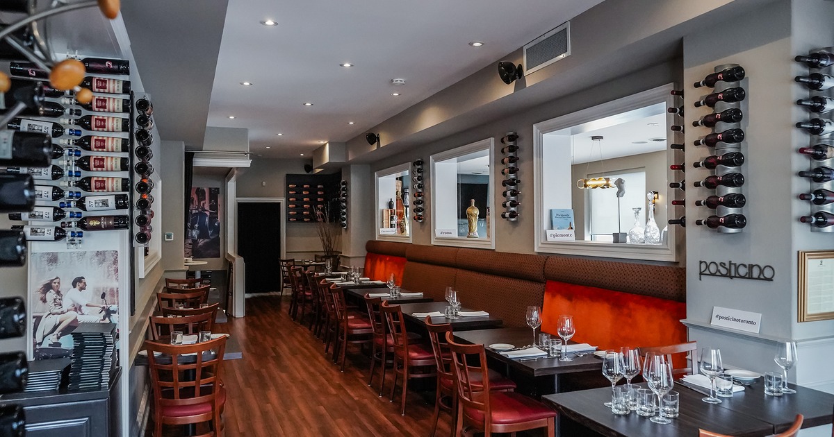Interior space, dining area with set tables, wall-mounted wine racks