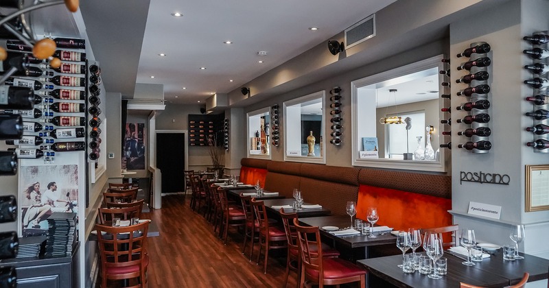 Interior space, dining area with set tables, wall-mounted wine racks