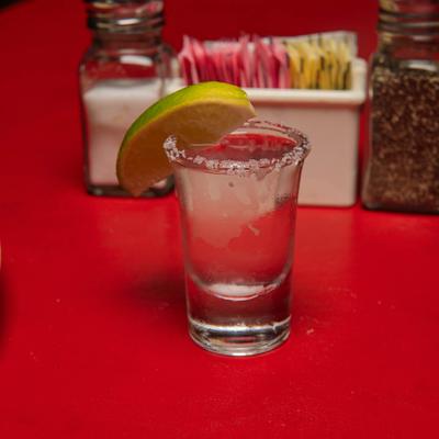 Shot of silver tequila with a salted rim and lime garnish.