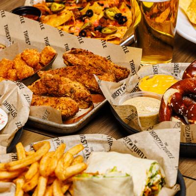 Various menu items served on the table with a glass of beer.