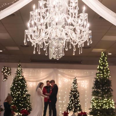 A wedding taking place under a beautiful chandelier.