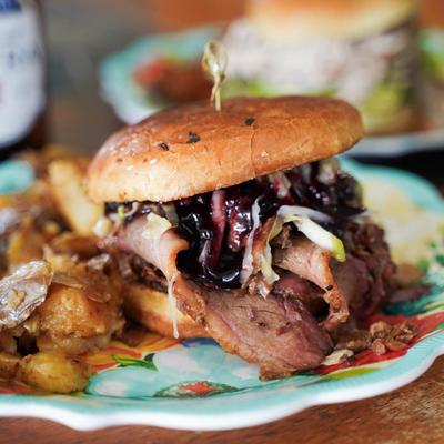 Smoked brisket sandwich with slaw and blackberry-chipotle sauce, served with roasted potatoes.