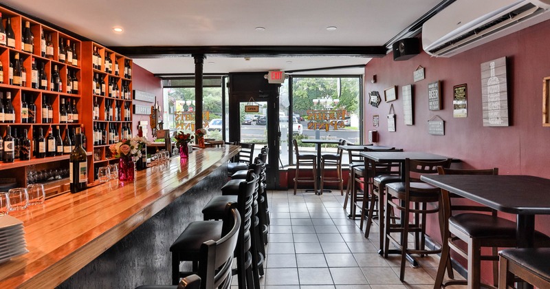 Interior seating area with stools, tables and a wooden bar