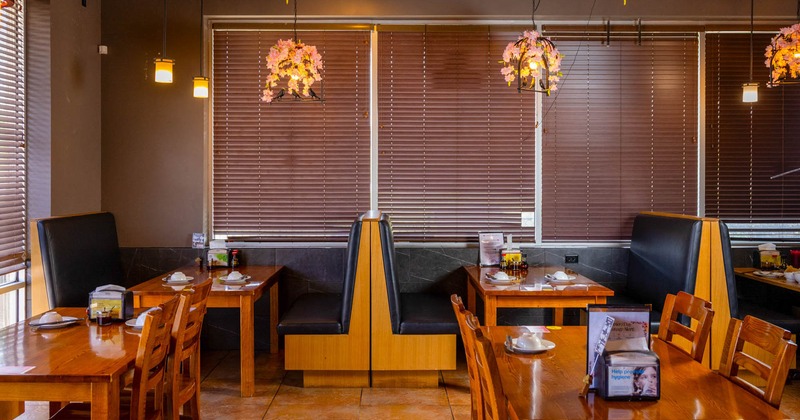 Interior, dining area, tables for four, seating booths, large windows with blinds, tile flooring