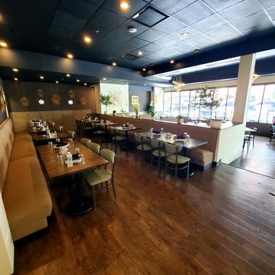 Dining space with wooden tables, booth seating, and a dark ceiling.
