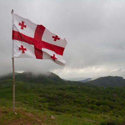 Georgian flag in wind and clouds