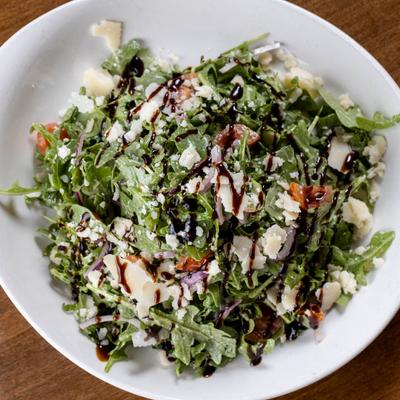 Salad with arugula, cherry tomatoes, red onions, shaved Parmesan, and balsamic.