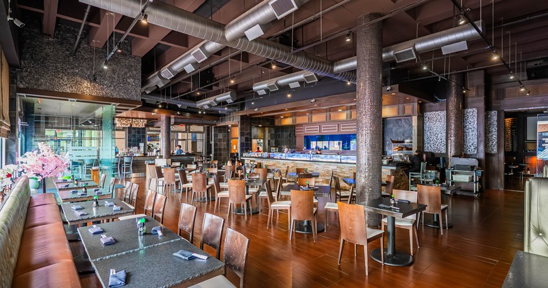 Interior, open space dining area, tables for two and four, banquette seating, sushi bar in the back